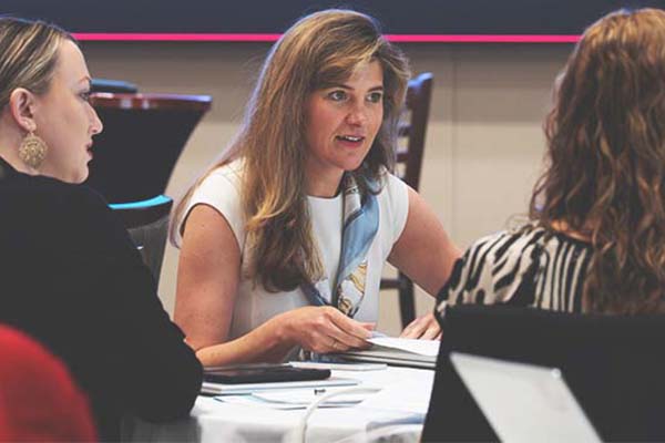A St. Louis Fed team member collaborates with two others during a workshop.